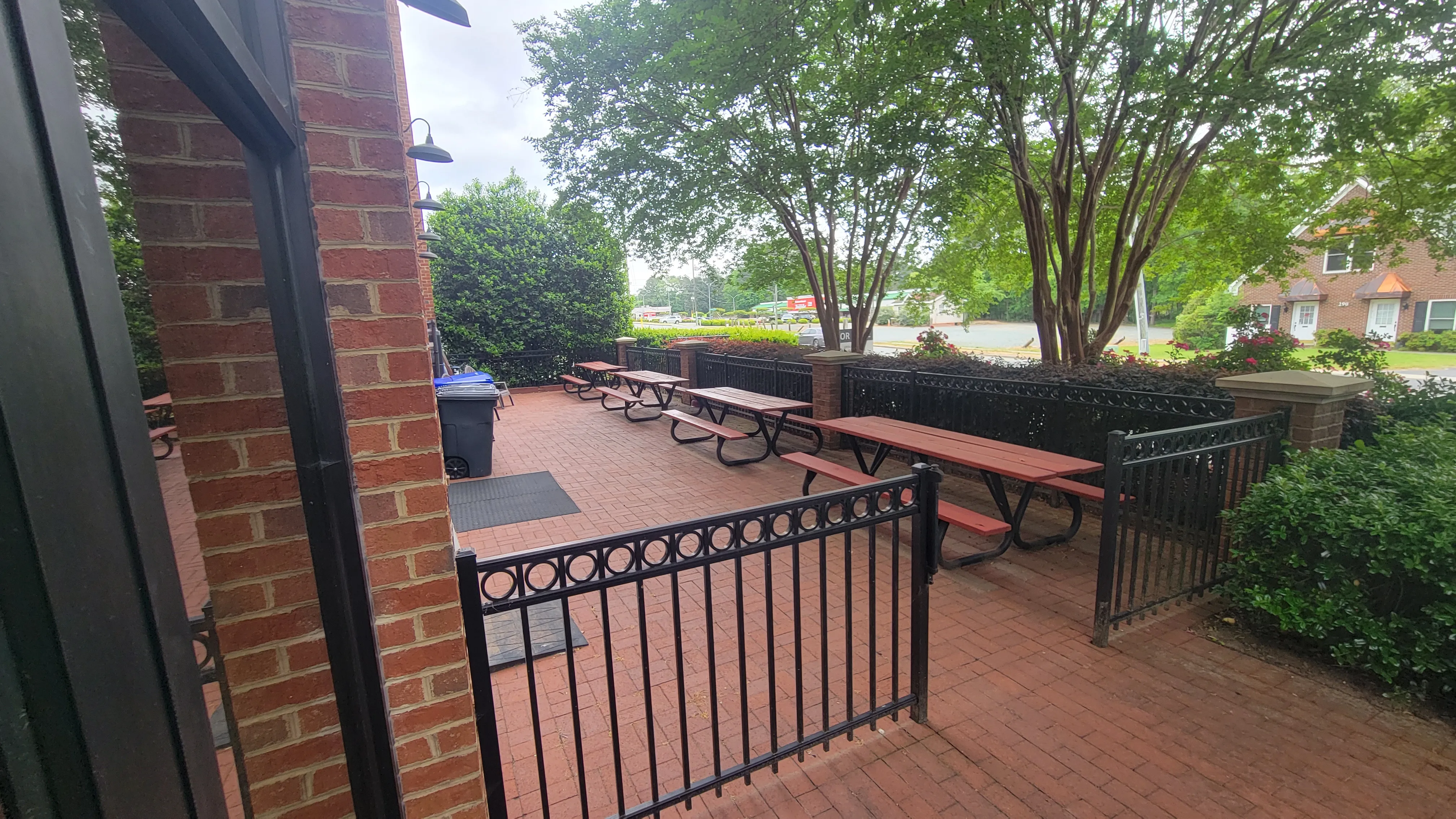 The shared outdoor patio at Main Street Station, with picnic tables under mature trees